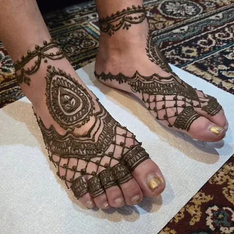 Henna on both feet with a paisley, an anklet band and a net pattern over the toes