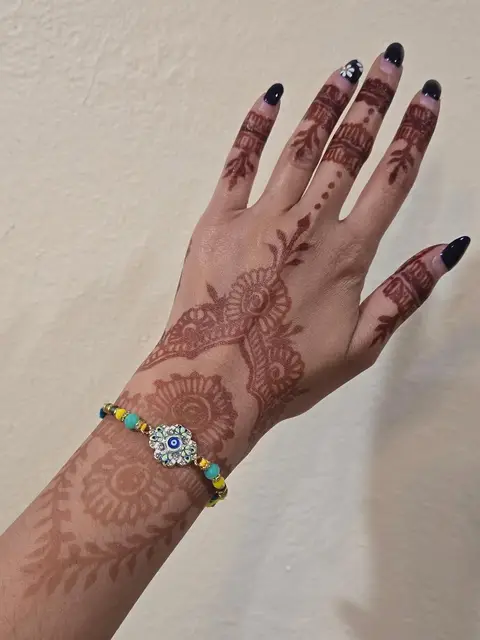 A soft floral trail across the back of a hand, worn with an evil eye bracelet